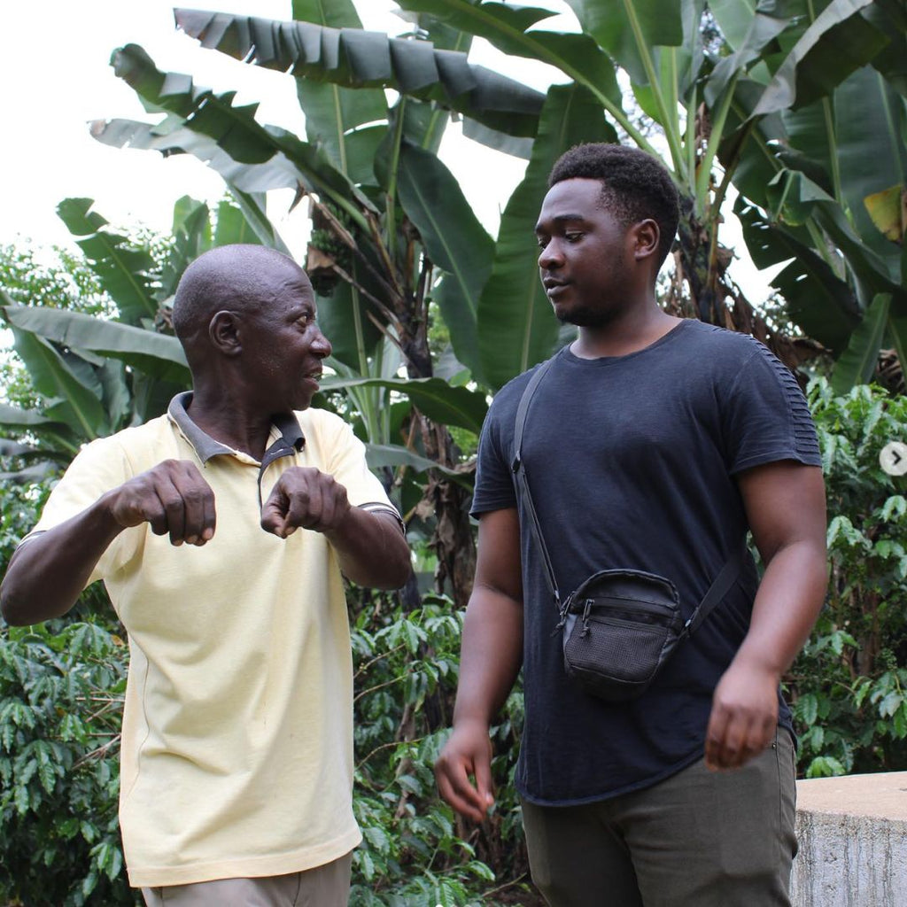 Edwin from Mount Elgon explaining how to pick coffee - or milk a cow.  One of the two.