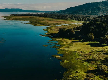 Lagoon surrounded by greenery with mountains in the background